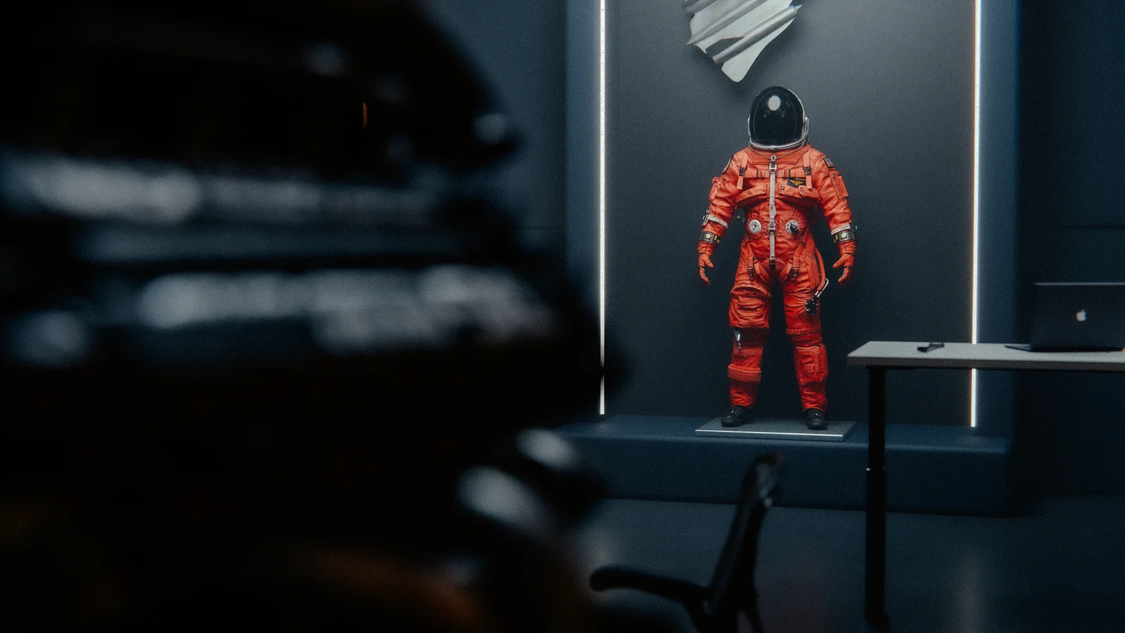 Orange spacesuit displayed in a glass case, rendered in 3D.
